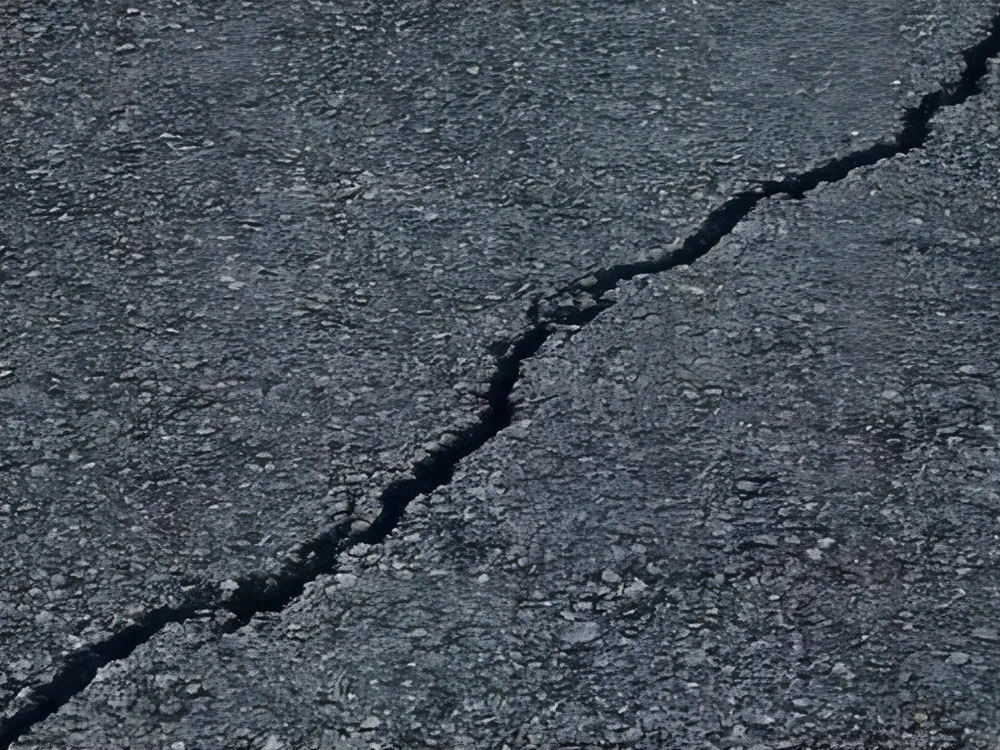 A crack appears on the asphalt road